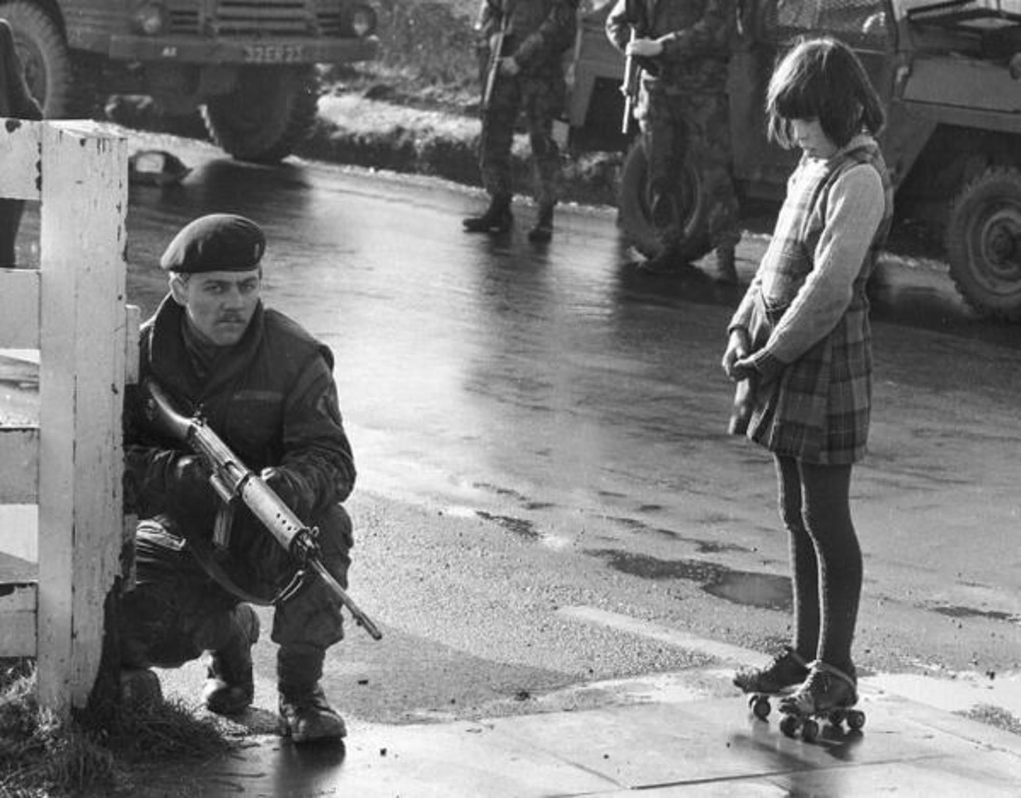 Любопытная девочка наблюдает за действием армейского патруля, Северная Ирландия, 1969 г.