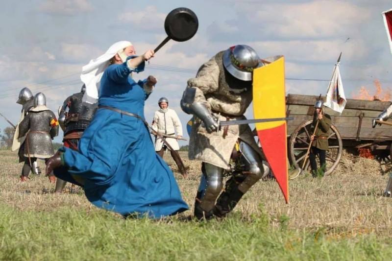 Случай на фестивале исторической реконструкции: "средневековая" женщина бьет сковородой пехотинца, вероятно — своего мужа.