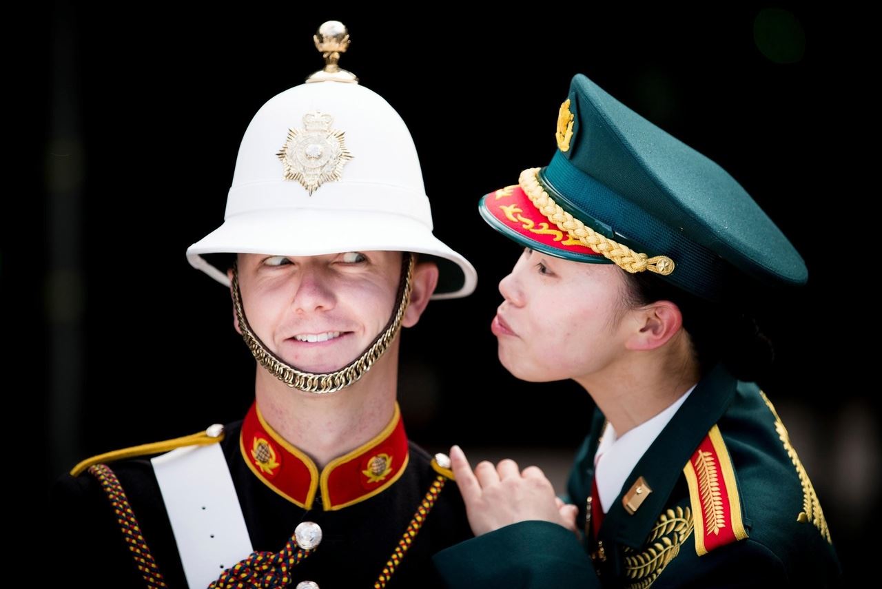 Сержант Аями Накама, музыкант из военного оркестра Японских сил самообороны, дурачится вместе с музыкантом из сводного оркестра Королевской морской пехоты Великобритании, 1 августа 2017 г.