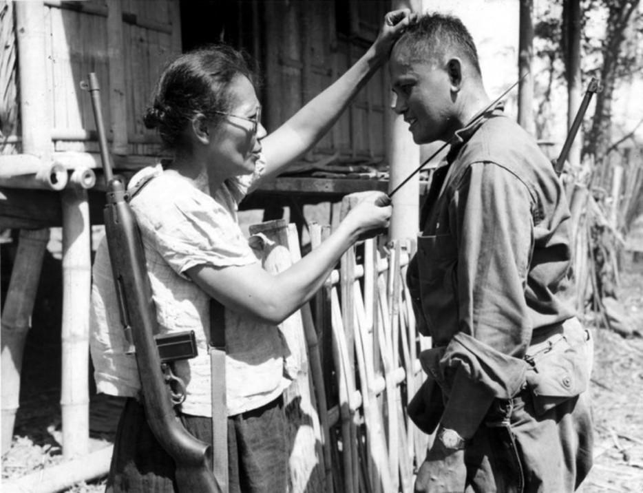 Филиппинская партизанка, капитан Ньевес Фернандес показывает американскому солдату, как она убивала японских солдат во время оккупации, 1944 г.