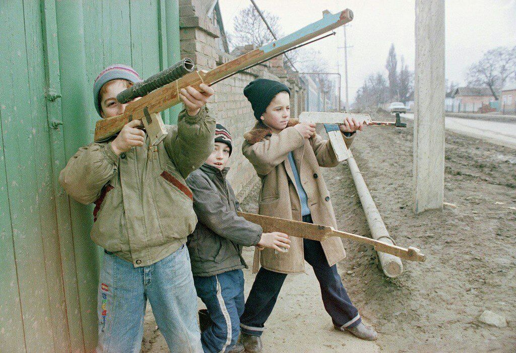 Дети играют с палками, воображая что это огнестрельное оружие, Россия, 1990-е гг.