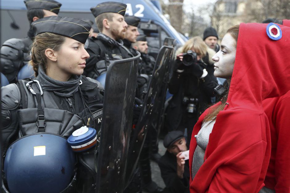 Девушка в образе Марианны, символа Французской революции, напротив полицейской, Париж, 15 декабря 2018 г.