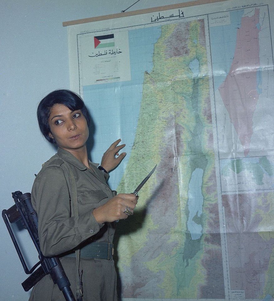 Знаменитая палестинская террористка и боевик НФОП Лейла Халед, вооруженная египетским пистолетом-пулемётом "Порт-Саид" и итальянским стилетом, у карты Израиля и Палестины, 1970-е гг.