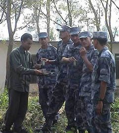 A Maoist soldier welcome policemen with cups of tea, 2006.jpg