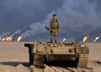 Американский военнослужащий на танке Т-62 иракской армии с оторванной башней. 1991 год.jpg