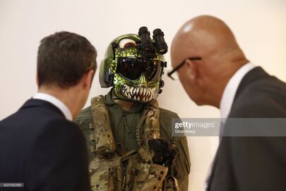 Visitors look at a mannequin wearing a HGU-56P rotary wing aircrew helmet, produced by Gentex Corp., on the second day of the Farnborough International Airshow in Farnborough, U.K., on Tuesday, July 15, 2014.jpg