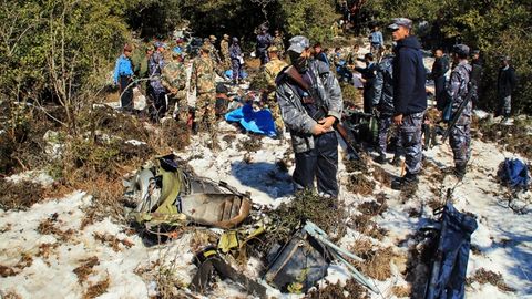 Nepalese police officers and army soldiers inspect the wreckage of Nepal Airlines' Twin Otter that crashed Sunday at Khachikot in Argakhanchi district in western Nepal, Monday, Feb. 17, 2014.jpg