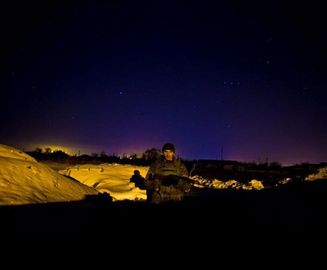 Боец роты Святая Мария на фоне ночного города где-то на востоке Украины, февраль 2015 г..jpg