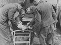 Два офицера люфтваффе перевязывают руку раненому пленному красноармейцу. СССР. ВМВ. 1941 г..jpg