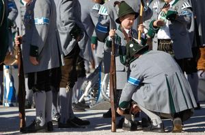 Баварский горный пехотинец в традиционной форме поправляет костюм мальчика для предстоящего парад.jpg