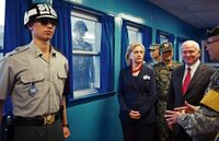 Северокорейский пограничник следит за американской делегацией во главе с Хиллари Клинтон во время её визита на 38-ю параллель.jpg