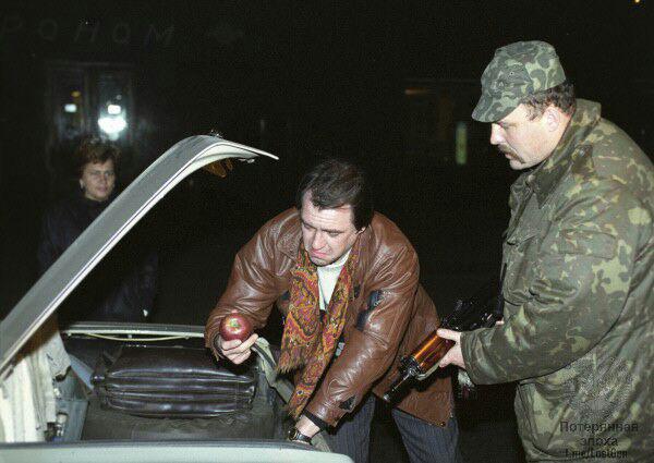 Житель Москвы, задержанный для обыска и проверки документов, с досадой держит в руках найденное в ходе досмотра яблоко, Россия, 1993 г.