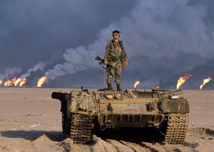 Американский военнослужащий на танке Т-62 иракской армии с оторванной башней, 1991 г. На фоне видны горящие нефтянные месторождения.
