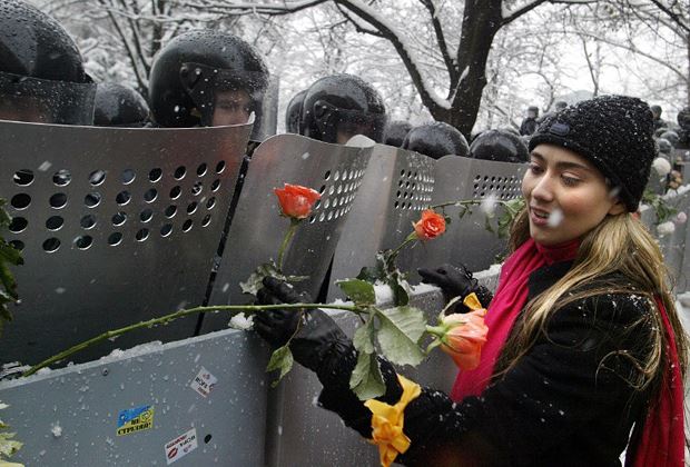 Девушка украшает щиты сотрудников милиции цветами во время Оранжевой революции в Киеве, 1 декабря 2004 г.