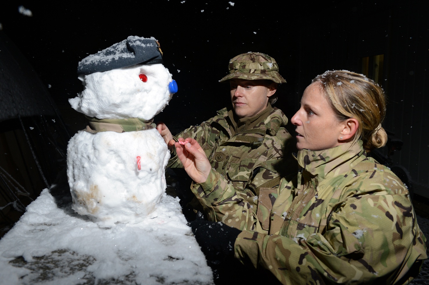 Британские женщины-солдаты лепят снеговика после первого сильного снегопада в Афганистане впервые за 8 лет, 2014 г.