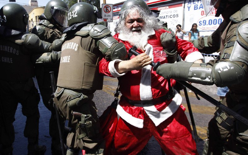 Чилийские карабинеры задерживают Санта-Клауса во время студенческих протестов 22 декабря 2011 г.