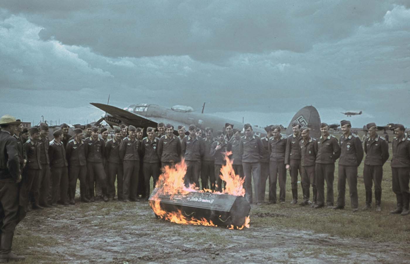 Пилоты люфтваффе на фоне Heinkel He 111 сжигают свой страх на ритуале приема новых летчиков в свои ряды, Харьков, 1942 г.