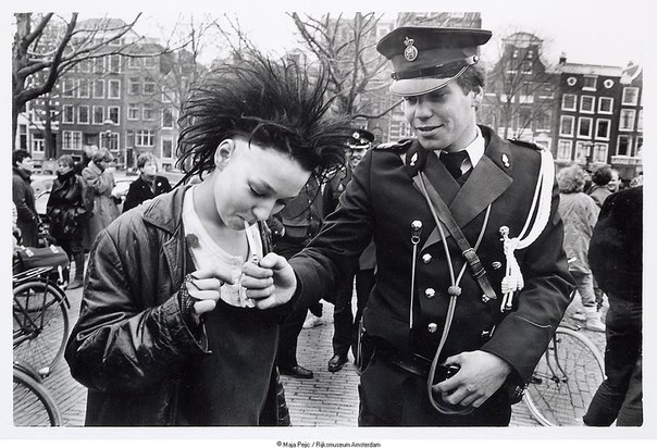 Полицейский даёт прикурить девушке-панку во время антиправительственной демонстрации в центре Амстердама, 1984 г.