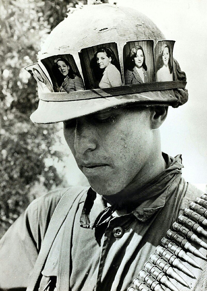 Американский солдат с фотографиями своей девушки на каске M1, май 1968 г.