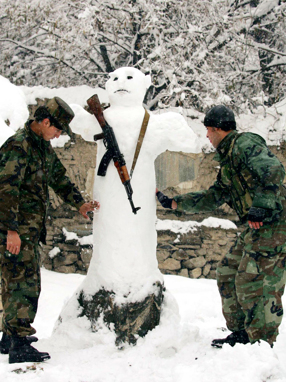 Афганские солдаты делают снеговика после сильного снегопада в Кабуле, Афганистан, 26 декабря 2006 г.