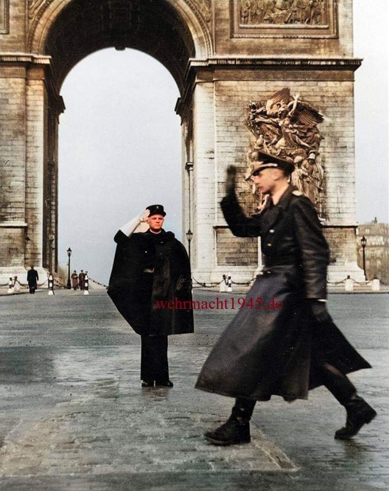Французский жандарм салютует немецкому офицеру на фоне Триумфальной арки, Париж, Франция, 1941 г.