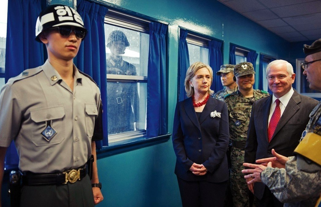 Северокорейский пограничник следит за американской делегацией во главе с Хиллари Клинтон во время её визита на 38-ю параллель.