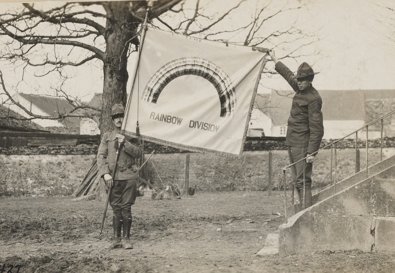 Бойцы "Радужной дивизии" с дивизионным флагом, на котором изображена радуга и прозвище дивизии, Франция, Первая мировая война.