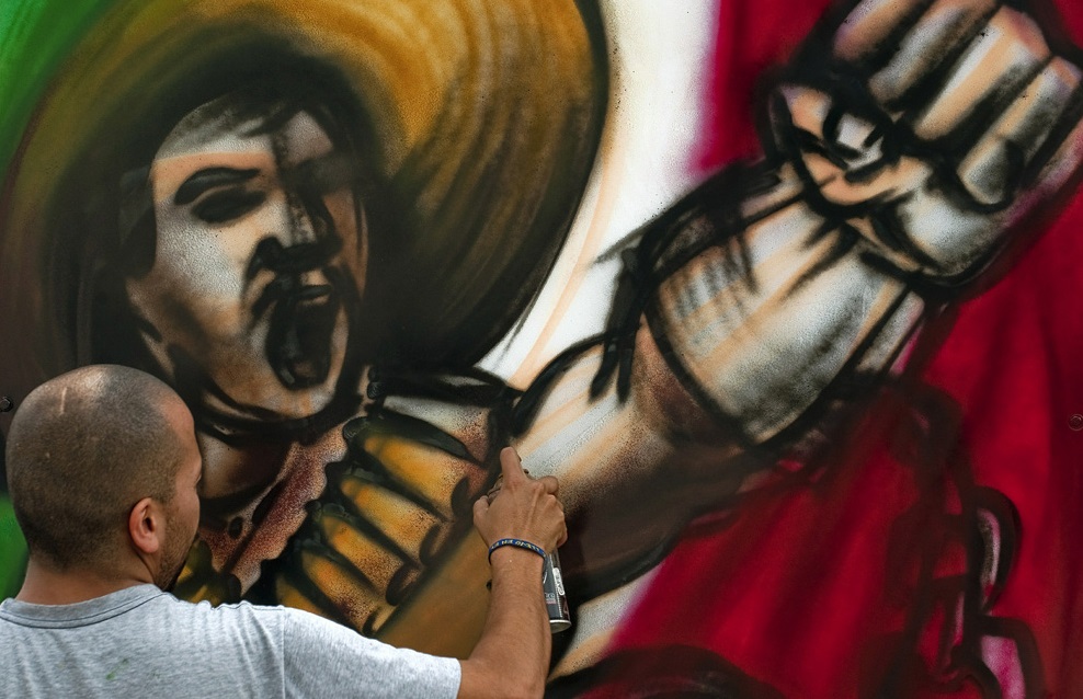 Уличный художник рисует граффити с изображением мексиканского революционера во время подготовки к празднованию Дня Независимости, 11 сентября 2010 г.