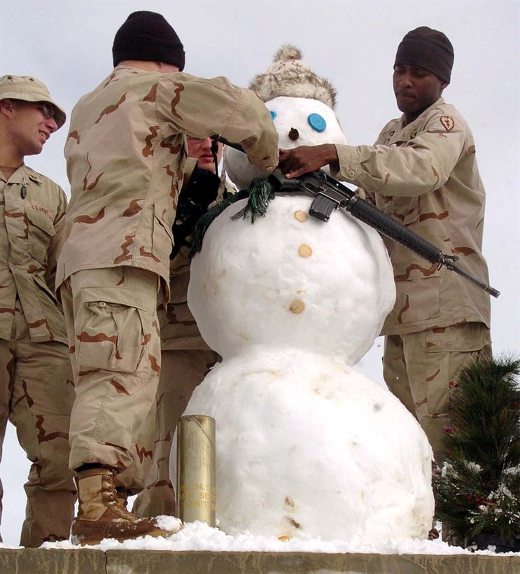 Солдаты батареи Б 3-го батальона 7-го полевого артиллерийского полка вешают на снеговика автомат M16, оперативная база Оргун-Э, Афганистан, 29 декабря 2005 г.