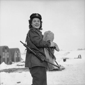 Private Kay Elms of the ATS, a member of 281st Battery, 137th (Mixed) Heavy Anti-Aircraft Regiment, carries a Sten gun at a camp in Belgium, 26 January 1944..jpg