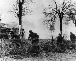 Немецкие солдаты проходят мимо уничтоженной колонны американской техники. Арденны, декабрь 1944 г..jpg