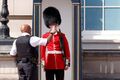 Лондонский полицейский дает попить караульному из Ирландского полка, Великобритания, 19 июля 2022 г.jpg