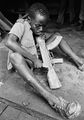 Ребенок вырезает себе деревянный автомат для последующих тренировок. Замбия. 1978г..jpg