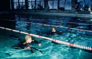 Советские курсанты МосВОКУ плавают в бассейне в полной униформе, со шлемом и АК, 1985 г.jpg