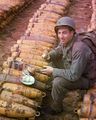 Американский солдат обедает на артилерийских снарядах, Вторая мировая.jpg