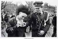 Полицейский даёт прикурить девушке-панку во время антиправительственной демонстрации в центре Амстердама, 1984 год..jpg
