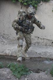 H Army Color Sgt. Patrick Canepa, Kandak Advisor Training Team 11 color sergeant and a Gibraltar native leaps over a stream with more than 80 pounds of gear on during Operation Atash, June 18 through 20..jpg