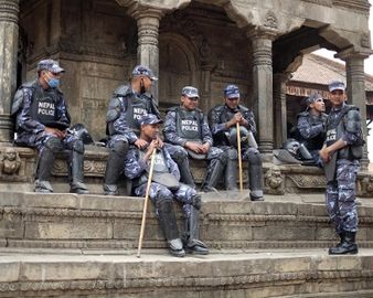 Непальские полицейские отдыхают на ступеньках индуистского храма во время праздника Бискет Джатра, Катманду, 2014 г..jpg