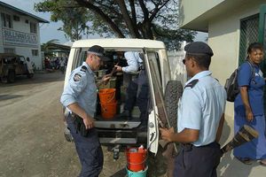 Royal Solomon Islands Police officers help their Australia Federal Police colleagues to load surrendered weapons at the National Peace Council headquarters in Honiara.jpg