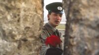 Солдат армии ГДР протягивает цветок через стену, 10 ноября 1989 года..jpg