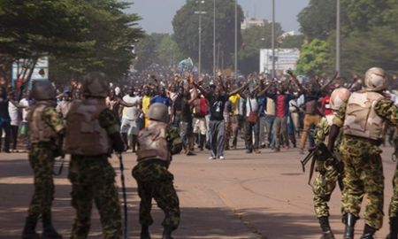 Soldiers attempt to stop anti-government protesters from entering the parliament building in Ouagadougou, October 30, 2014.jpeg