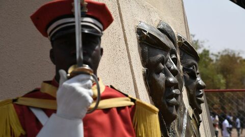 Un membre de la garde d'honneur se tient sous la statue de bronze de l'ancien président du Burkina Faso, Thomas Sankara, le jour de l'inauguration de son mémorial au Conseil de l'Entente de Ouagadougou, le 2 mars 2019..jpg