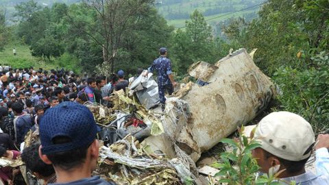 Onlookers and rescuers are seen near the wreckage of the aircraft in Lalitpur, on the outskirts of Kathmandu, on September 25. 2011.jpg