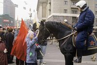 Мальчик, с флагом СССР и свёртком запихнутым в карман куртки, гладит коня сотрудника милиции. Москва, период митингов весны 1993 г.jpg