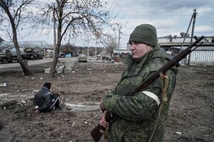 Боец народной милиции ДНР с винтовкой Мосина на плече охраняет подозрительного задержанного.jpg