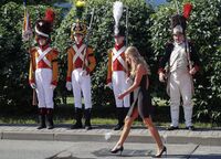 A woman passes Members of historical clubs during ceremony of repatriation of the remains of French General Charles-Etienne Gudin de la Sablonniere, Vnukovo-3, Russia, 13 July 2021.-min.jpg